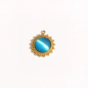Detailed view of a gold sunflower pendant with a blue cat-eye stone and beaded edge