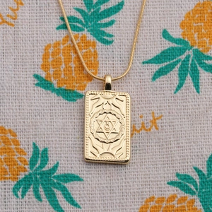 Gold plated square pendant necklace featuring embossed moon and hexagram star details