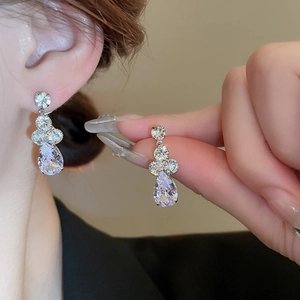 Détail des boucles d'oreilles goutte en argent avec zircons étincelants et vue portée
