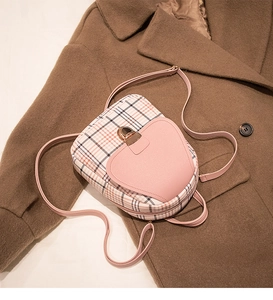 Pink lychee leather and plaid pattern backpack detail featuring gold heart clasp lock