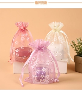 Floral organza drawstring pouches in pink, purple, and beige for gift packaging