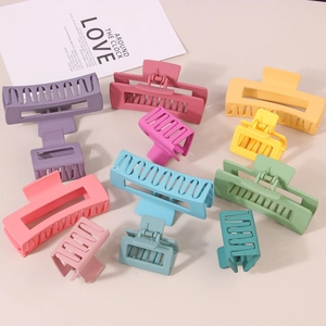 Flat lay of colorful matte plastic hair claws in various sizes and vibrant pastel shades