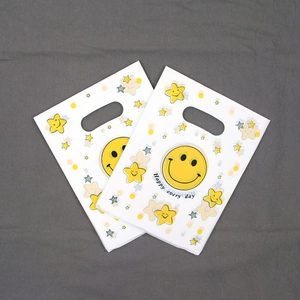 Set of 2 white plastic shopping bags featuring a yellow smiley face and star patterns