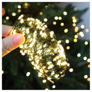 Detailed view of warm yellow LED copper wire lights on green wire for tree decoration