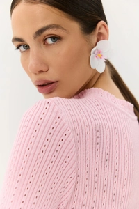 Dettaglio della maglia pointelle rosa e del delicato motivo traforato di un abito estivo