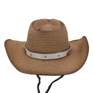 Detail of brown straw cowboy hat featuring a white leather band and silver metal studs