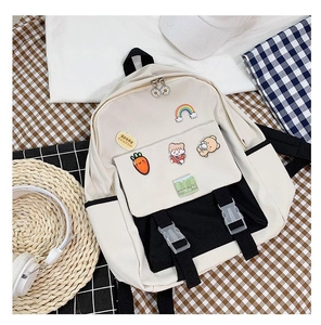 Detail of a black and white canvas backpack with colorful decorative pins and pockets