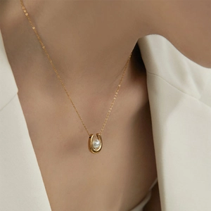 Élégant collier en acier titane en forme de U avec perle blanche sur mannequin en costume