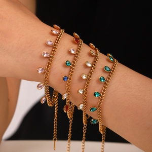 Detail of 18K gold-plated bracelets featuring colorful teardrop zircon charms on wrist