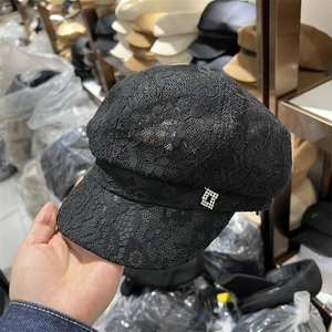 Detailed macro view of black lace octagonal cap with silver rhinestone buckle ornament