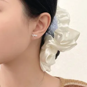 S999 sterling silver bow knot stud earrings for women shown on a model