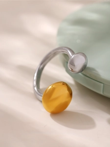 Vue détaillée d'une bague ouverte géométrique bicolore avec des formes polies or et argent