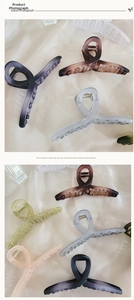 Close-up of matte large hair claw clips featuring streamlined curves and metal springs