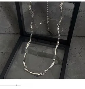 Detail shot of irregular liquid metal chain necklace in a black floating frame display