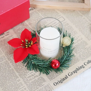 Christmas poinsettia candle ring with red and gold baubles and a white pillar candle