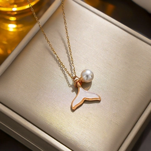 Elegant 18k gold fishtail pearl necklace for women on a beige textured jewelry box