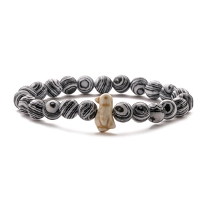 Macro detail of elastic bead bracelet featuring striped agate and white penguin charm