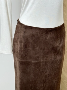 Detail of high-waist slit suede skirt in dark brown showing fine fabric texture and cut