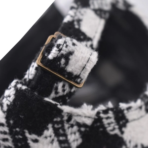 Detail of tweed baseball cap with vintage metal buckle and textured woven fabric