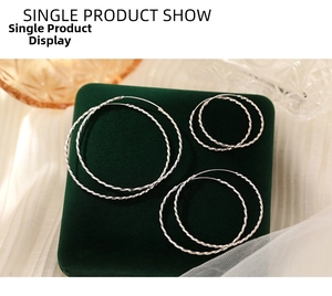 Three pairs of s925 sterling silver twist hoop earrings on dark green velvet tray