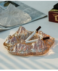 Macro detail of iceberg-style glass ashtray in amber gold finish with thick texture