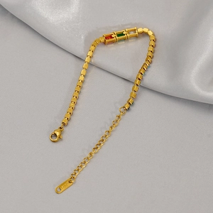Close-up of 18K gold-plated bracelet with rectangular red, green, and clear stones