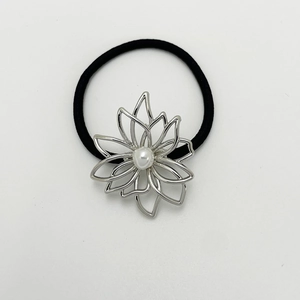 Detail of silver hollow flower hair tie with pearl center and black elastic band