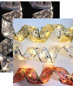 Detail of LED Christmas ribbon lights with gold stars and musical patterns on mesh fabric