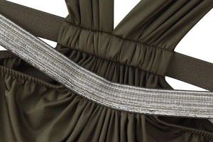 Macro detail of olive green ruched swimsuit fabric with metallic silver elastic strap
