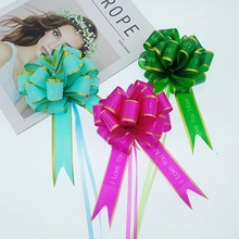 Detail of colorful macaron gift bows in blue, rose, and green with golden edge and I Love You text