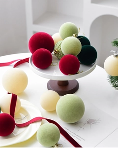 Flocked Christmas ball ornaments in mixed colors and sizes on a festive tray