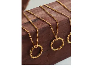 Macro view of gold-plated twisted rope ring pendants on delicate chain necklaces