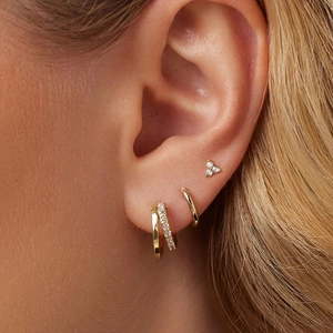Detailed view of three-piece gold-plated S925 silver earring set on ear featuring zircon pavé