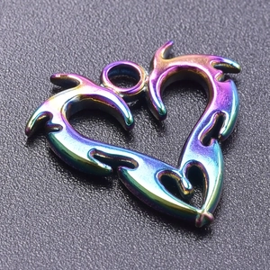 Macro detail of iridescent flame-etched stainless steel heart pendant with 18k gold plating