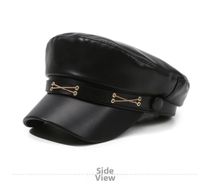 Detail view of black faux leather baker boy hat with gold chain and vintage buttons