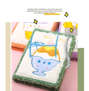 Detalle de la portada de cuaderno de felpa con pelo blanco y bordado de bebida dulce
