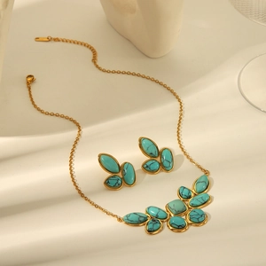 Detail of turquoise necklace and earrings jewelry set in gold-finished metal