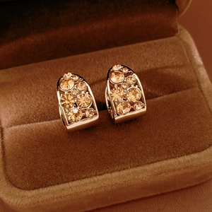 Gros plan sur des boucles d'oreilles vintage en forme de U en strass champagne et velours