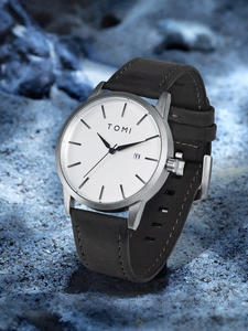 Detailed macro view of minimalist white watch dial with date display and black leather strap