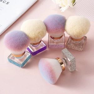 Close-up detail of rhinestone-encrusted makeup brushes with soft pastel bristles.