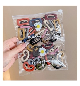 Detail view of colorful heart and rectangular macaron hair clips in clear packaging