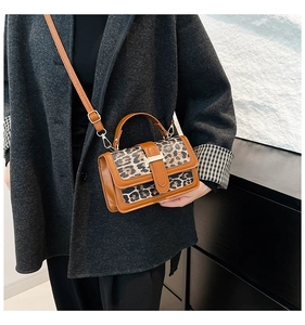 Detail of leopard print leather crossbody bag with iconic gold H-shaped metal clasp