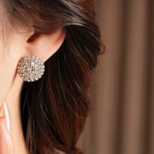 Gros plan de boucles d'oreilles rondes en argent serties de diamants sur le mannequin