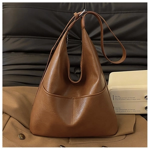 Gros plan sur la texture du sac cabas en cuir marron vintage sur un blazer