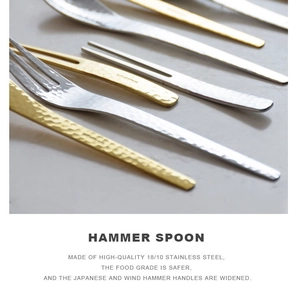 Close-up of golden and silver 18/10 stainless steel spoons with hammered wide handles