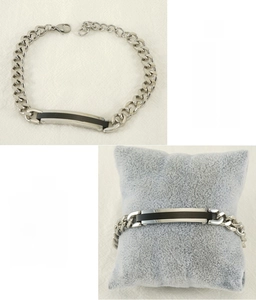Gros plan d'un bracelet gourmette en acier argenté avec plaque noire rectangulaire