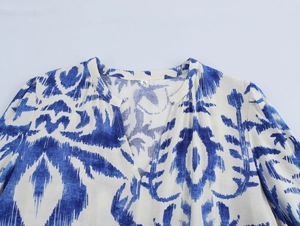 Detailaufnahme des V-Ausschnitts am Kleid mit blauem Bohème-Muster und weißem Größenetikett S
