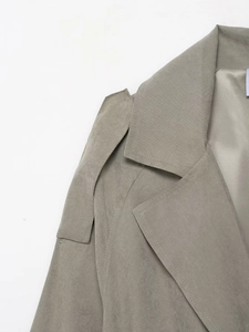Close-up of lapel and shoulder strap details on a loose sage green faux suede jacket