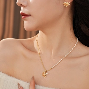 Exquisite golden necklace and stud earrings set with orange butterfly and pearl details