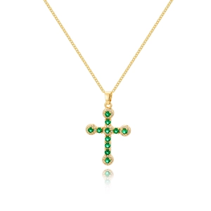 Collana a croce dorata con zirconi verde smeraldo e diamanti chiari su sfondo bianco